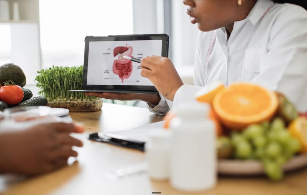 A digestive-wellness consultation explaining gut-brain health pathways with nutrition and educational visuals